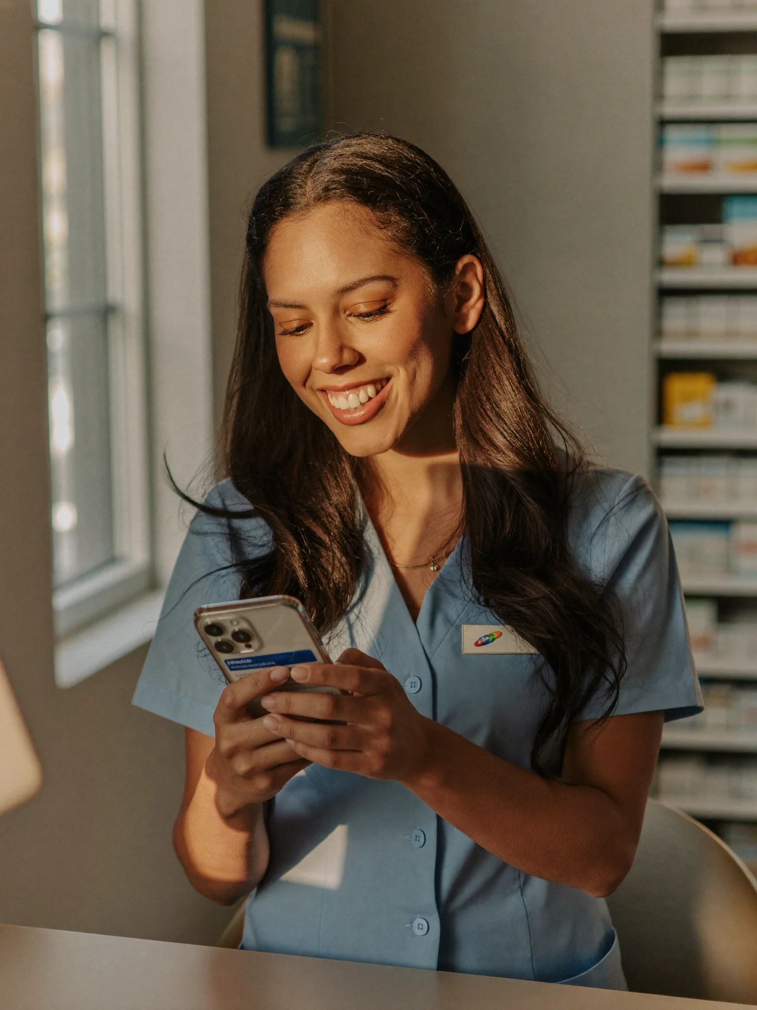 Atendente sorrindo ao ver notificação do LinkedIn no celular